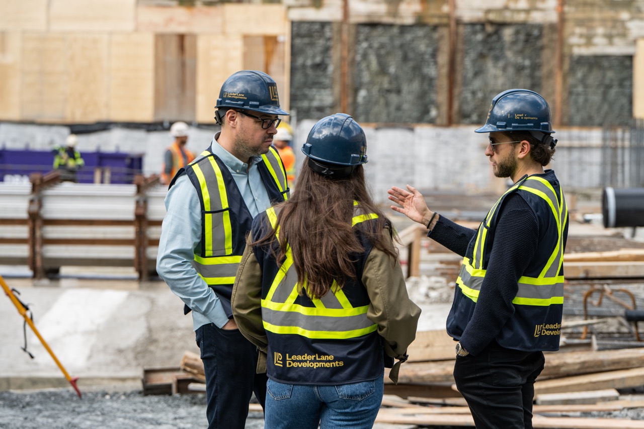 Leader Lane Developments team members in conversation on a construction site